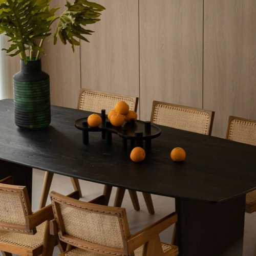 a dining room with a table, chairs and a plant