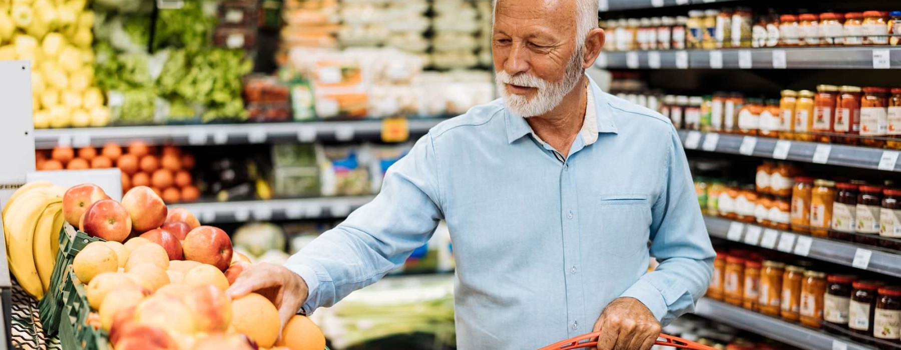 a person holding a shopping cart in a grocery store