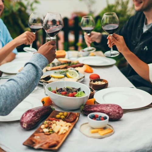 a group of people sitting around a table with drinks and food